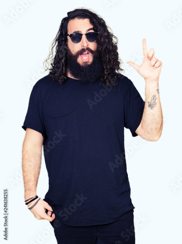 Young Hipster Man With Long Hair And Beard Wearing Sunglasses