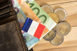 Eine Geldbörse, Euro Geldscheine und Münzen und Flagge von Frankreich