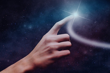 Leinwandbilder - Forefinger touches a new star in infinite space.