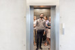 © MDBPIXS - Confident business people standing in elevator at office