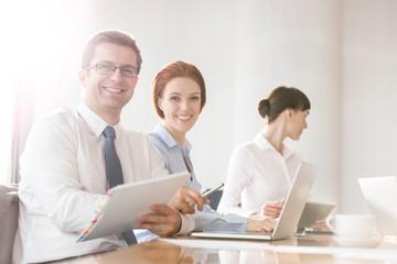 Portrait of business colleagues working at table in boardroom