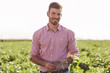 © Zoran Zeremski - Portrait of young farmer standing in filed examining soybean corp.