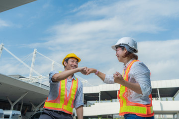 Male and Female Industrial and civil engineers wear personal protective equipment, happy and giving fist bump after project complete, partnership agreement, teamwork together and business success.