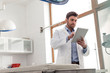 © MDBPIXS - Veterinary doctor using digital tablet while standing at clinic
