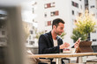 © Westend61 - Businessman sitting in cafe, drinking coffee, using smartphone