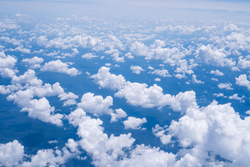 Sky scape cloudscape from aerial airplane shot of blue clouds. View flying above moutain from windows over Loei, Thailand.