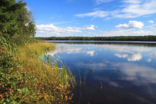 Northern Michigan Wilderness Lake. Sunny Blue Sky And Clouds Reflected At A Beautiful Remote Inland Lake In The Hiawatha National Forest Of The Upper Peninsula.
