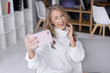 © fotoplaton - Beautiful happy girl taking pictures of herself on a mobile phone. Selfie photo.
