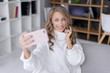 © fotoplaton - Beautiful happy girl taking pictures of herself on a mobile phone. Selfie photo.