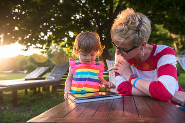 Sticker - mom and her little daughter using tablet computer