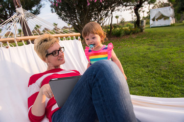 Sticker - mom and a little daughter relaxing in a hammock