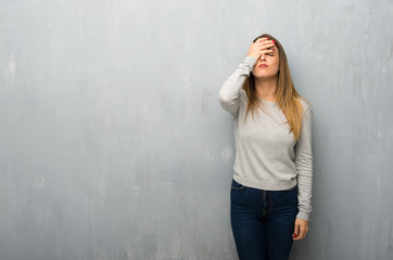 Young woman on textured wall with surprise and shocked facial expression