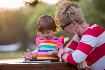 Sticker - mom and her little daughter using tablet computer