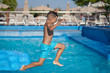 © Artem - Boy having fun in swimming pool at hotel. He making jump from inflatable mattress into water.