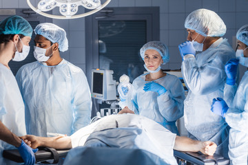 Poster - Female nurses putting oxygen mask on patient in operation room. Jaw thrust maneuver technique for give oxygen and medication via mask from ventilator machine