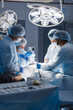 © alfa27 - Complex surgery. Skilful surgeon works with scalpels and clamps during an operation, and his asistants taking care of blood removal from the cut