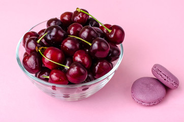 Wall Mural - Glass bowl with cherry on pink background