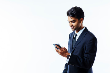 Portrait of a handsome businessman entrepreneur writing a note on his phone, smiling, looking down, isolated white background.