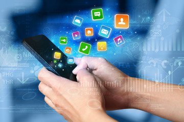 Hand using phone with bouncing colorful application and global reports and graphs concept
