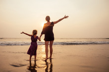 Mothers Day Concept Of Love, Parenthood And A Happy Family. Mother And Child Daughter Having Fun At Sunset On Beach