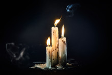 Group Of White Candles Burning In The Dark