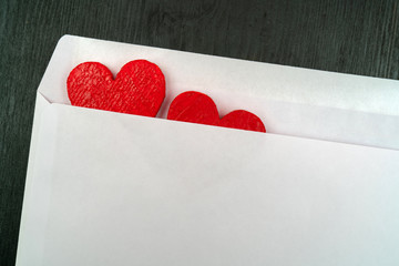 Two red hearts in a white envelope.