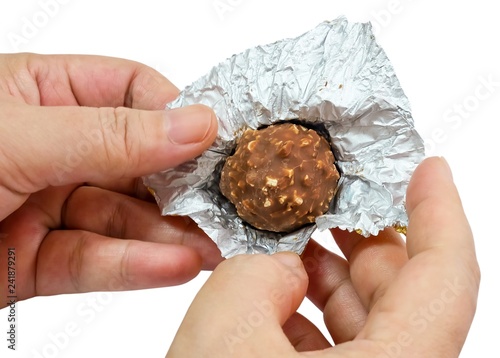 Fotografie, Obraz Hand Holding Round Chocolate Candy in Gold Package