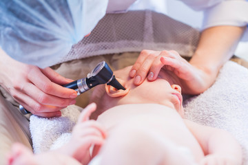 doctor looks at the ear with an otoscope