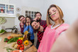 © Davide Angelini - Group of crazy friends having fun in the kitchen cooking vegetables and pasta