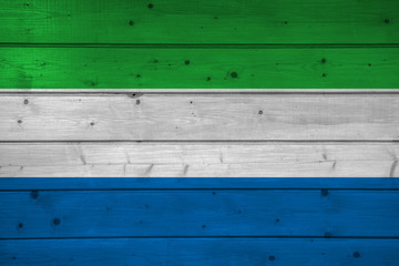 Wall Mural - Flag of Sierra Leone on wooden background, surface. Wooden wall, planks. National flag