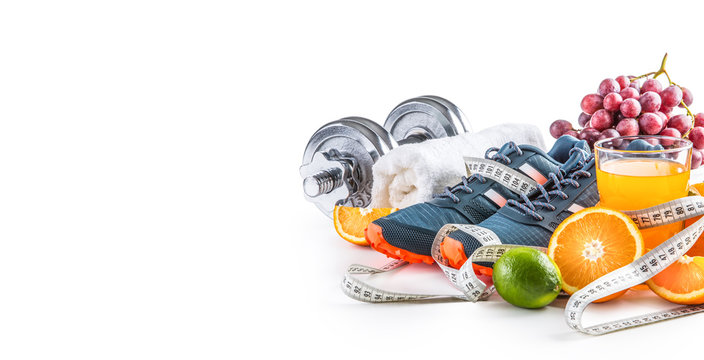 sport shoes dumbbells fresh fruit measure tape and multivitamin juice isolated on white background. 