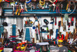 A collection of assorted tools hanging on the wall with a work bench in a garage