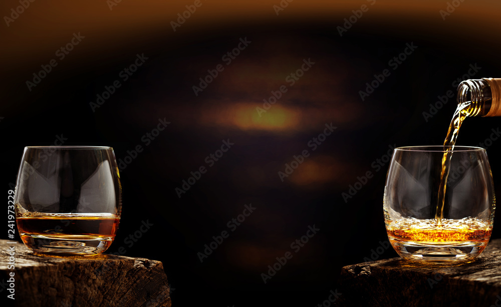 Pour whiskey out of the bottle in whiskey glass in the bar - obrazy, fototapety, plakaty 