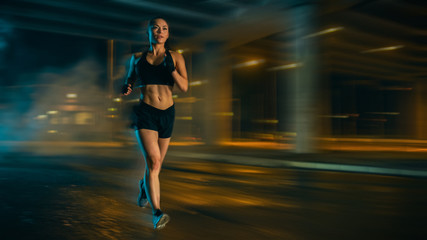 Wall Mural - Burred Motion Shot of a Beautiful Fitness Girl in Black Athletic Top and Shorts is Jogging on the Street. She is Doing a Workout in an Evening Wet Urban Environment. Running Through Time.