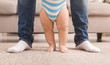 © Prostock-studio - Baby boy learning to walk with help of father