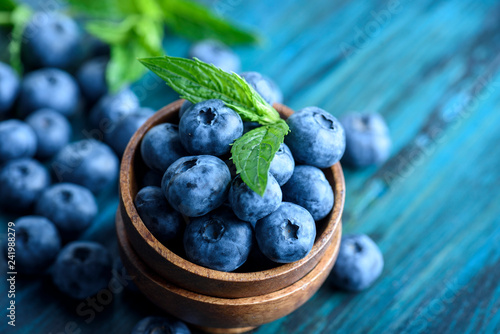 Cuadros en Lienzo Bowl of fresh blueberries on blue rustic wooden table closeup.