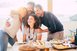 © simona - Group of friends have fun together during a lunch outdoor in the terrace at home and taking a modern selfie with smart phone to share on social media accounts for internet life - happy adult people
