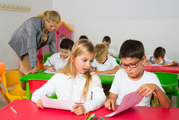 Portrait of schoolgirl and schoolboy at desk