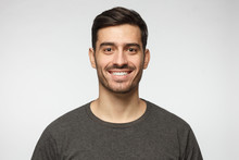 Close-up Portrait Of Smiling Handsome Young Man In Casual T-shirt, Isolated On Gray Background