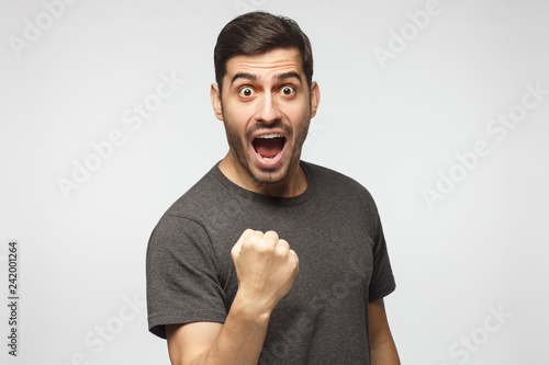 Fotografie, Obraz Emotional mn celebrating victory and acting as if he is winner, raising fist, sh