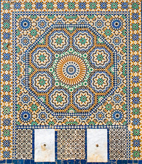 Naklejka na meble Traditional ornamental drinking fountain in medina in Meknes, Morocco. Decorated fountain with mosaic tiles. Ornate mosaic and traditional Islamic religious art. Ancient oriental Moroccan