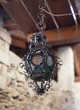 una vecchia lampada in ferro decorata appesa fuori di una casa in montagna