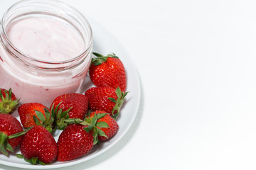 Wall Mural - strawberry yogurt in glass jar and fresh berries on white background, top view