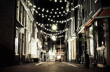 Wall Mural - Night Amsterdam with night lights. Urban night European landscape. Large European stylish city. Beautiful stylish modern homes in Amsterdam. Light garland over the houses.