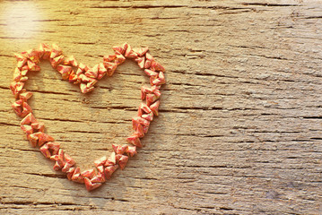 Top view of folding paper in little heart shape put on the wooden plate in the heart shape