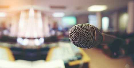 Vintage microphone over the Abstract blurred image of conference hall, study room or seminar room with attendee background, Small Business training concept, Public speaking