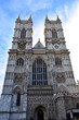 Westminster Abbey. West gothic facade and towers with clock, windows and statues. London, United Kingdom.