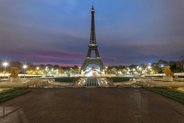 Wall Mural - Very early morning sunrise on the Eiffel tower not lit at all, view from the Trocadero fountain water in Paris, one of the most visited building by the tourists