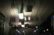 © artesiawells - Abstract moody dew view on window with lights in commuter train transit area