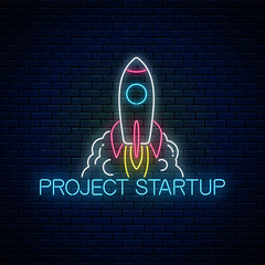 Wall Mural - Glowing neon sign of business project startup. Business fast start symbol as a flying rocket in neon style.